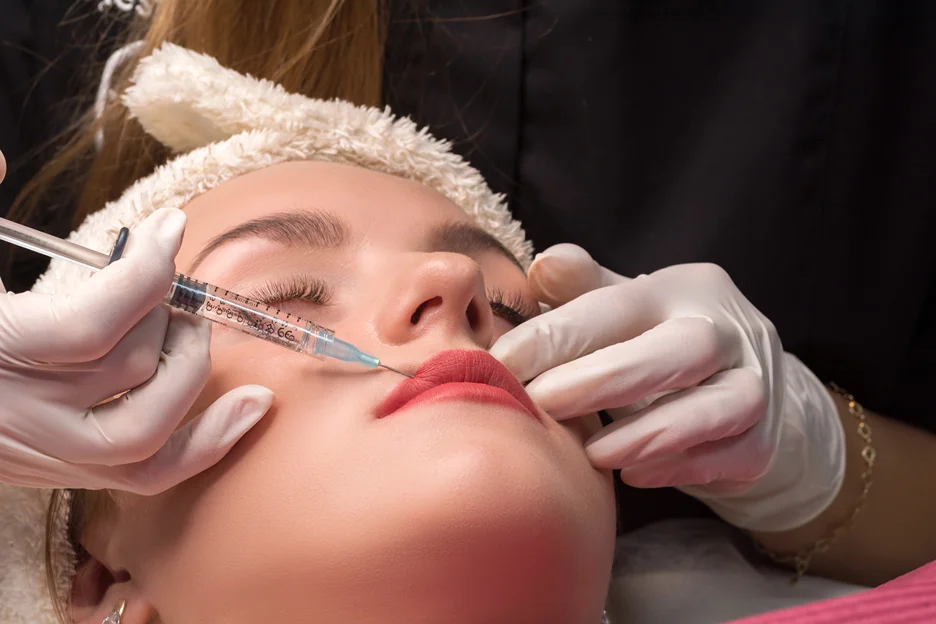 a woman receives lip filler injections
