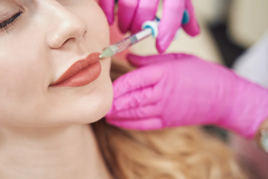 a woman undergoes lip fillers procedure for gummy smile