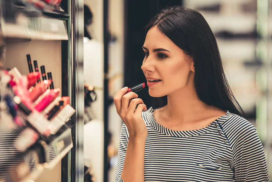 a woman chooses lipstick from the store