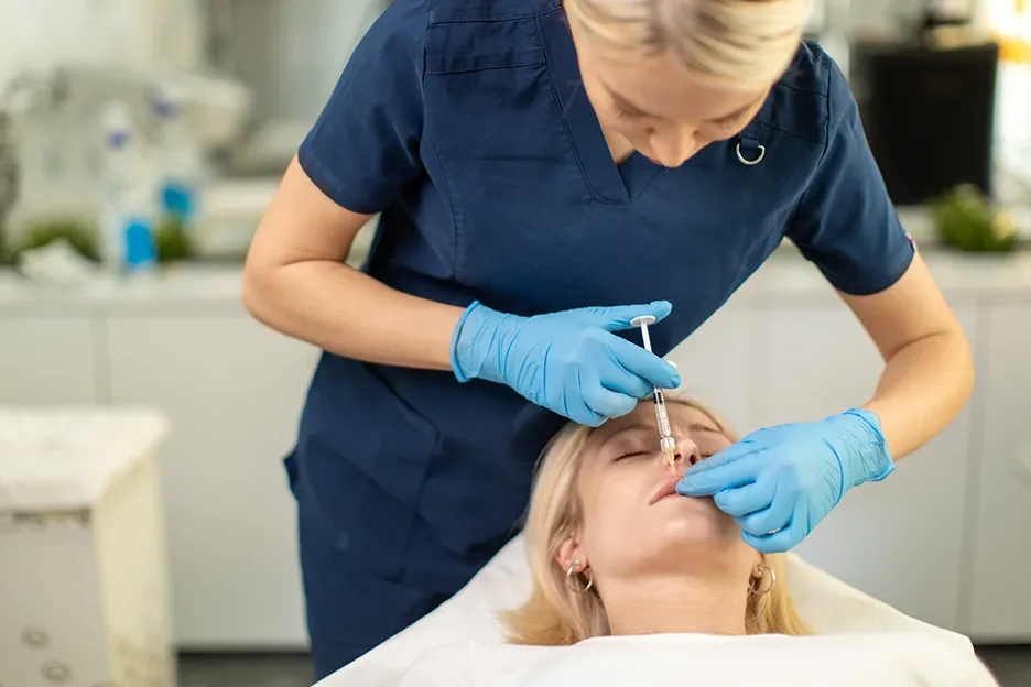 medical professional injects lip fillers on the patient's lips