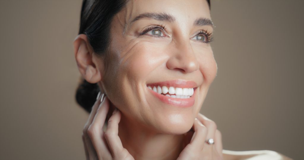 Woman smiling with smooth, radiant skin after cosmetic dermatology facial treatment.